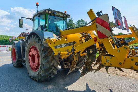 Modern Fendt tractor with Bednar cultivator on rural road in Mecklenburg