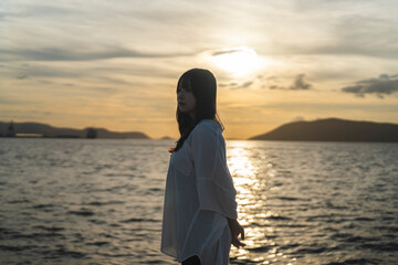 夕日の海にいる女性