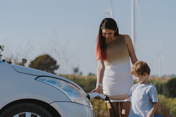 Mother and child charging electric car, green energy, environmentally friendly, car charging...
