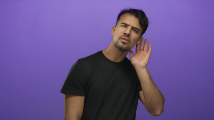 Young hispanic man listening gesture over isolated purple background conveys curiosity and attention