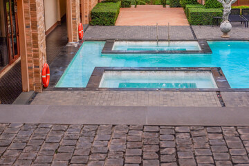 Empty swimming pool with sunbed and white umbrella in resort hotel for vacation leisure and white sand,resort neary sea and beach in summer.
