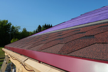 Laying of shingle soft tiles on the roof of a country house. It is made of modified bitumen and...