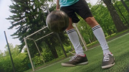 Low angle shot of young Caucasian soccer player juggling ball near goalpost on grassy field, highlighting control, skill, and technique in outdoor training - Powered by Adobe