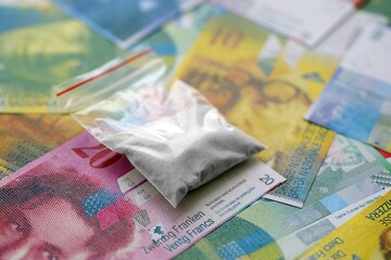Swiss franc banknotes and cocaine pack. The current francs money bills and narcotic substance