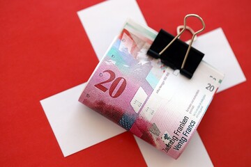 Swiss franc banknotes and flag. The francs money bills lies on flag in big amount