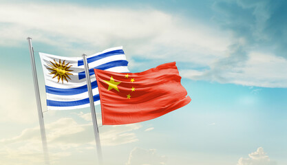 Uruguay and China flags waving in beautiful sky. Two country flag for agreement or deal. Uruguay...