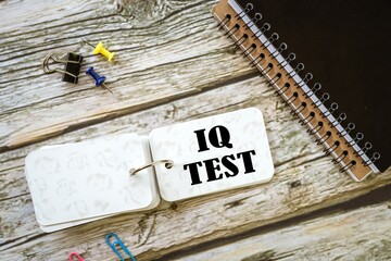 IQ TEST words on a small notebook. a beautiful wooden table. a pile of notebooks.