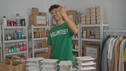 Volunteer man with finger pointing to stacked food trays at donation center building; compassion community support generosity.