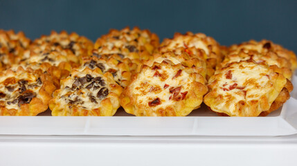 A tray of assorted pastries, including some with cheese and some with bacon
