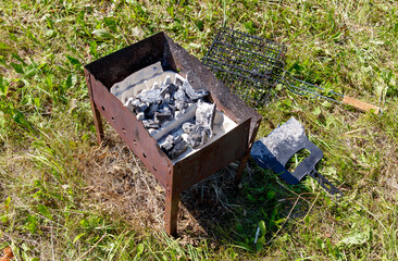 A charcoal grill with a spatula and a piece of paper on top of it