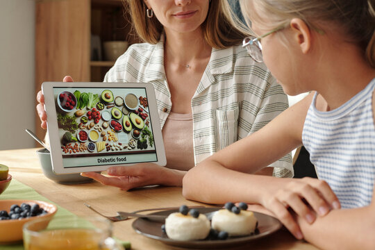 Parent and child viewing diabetic menu on digital tablet at home