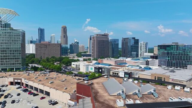 Modern Skyline of Atlanta buckhead district with mirrored and glass skyscrapers. Sunny summer day in America. Cars parking on top of deck. Aerial rising wide shot.