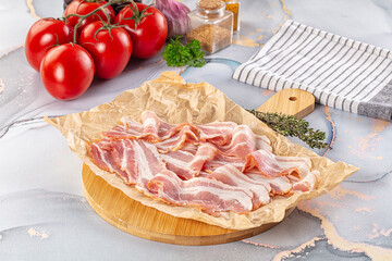 Sliced pork bacon over board