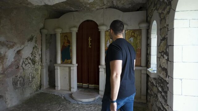 A Man Inside The Basarbovo Rock Monastery Near Ruse In Bulgaria. Slow Motion Shot