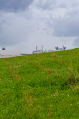 Fototapeta premium Green Hillside with Industrial Elements