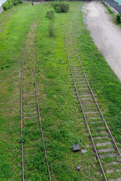 Overgrown Railway Tracks in Green Landscape