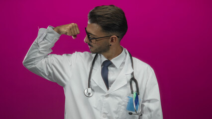 Hispanic doctor wearing white coat and stethoscope flexes bicep in vibrant pink studio; empowerment...