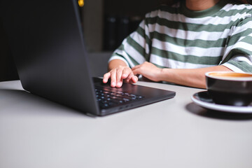Closeup image of a businesswoman working and touching on laptop computer touchpad