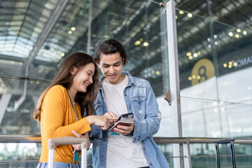 Asian young couple passenger standing outdoors of airport terminal.