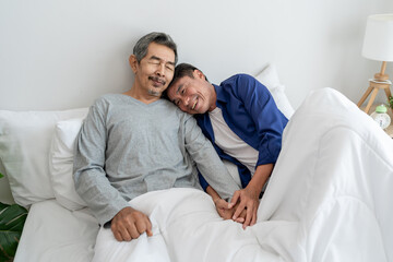 Asian elderly older male gay couple sitting on bed in bedroom at home. 