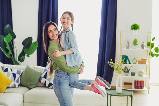 Happy mother and daughter enjoying quality time together in a cozy home environment, showcasing love and familial bonds.