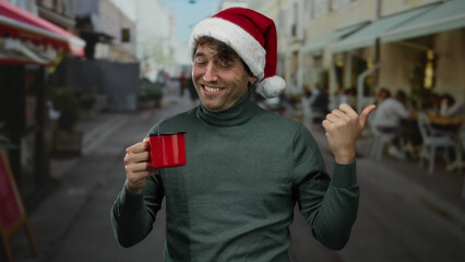 Hispanic man wearing christmas hat smiling holds red cup while pointing on busy street suggesting a...