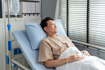 Asian elderly male patient lying on a hospital bed in the recovery room. 