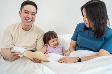 Asian mature parents lovingly care for and raises baby girl at home. 