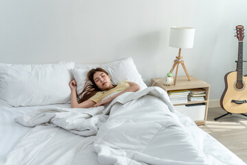 Asian beautiful woman lying down on bed in bedroom in morning at home. 