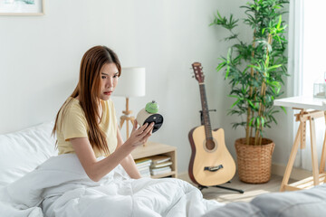Asian young beautiful woman getting up from sleep on bed in the morning.