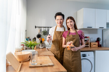 Portrait of Asian young couple enjoy daily housework routine together.