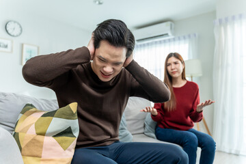 Asian stressed woman and aggressive man screaming at each other in house. 