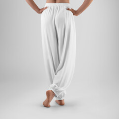 Mockup of white wide pants with elastic bands on a posing woman, training clothes close-up, back...