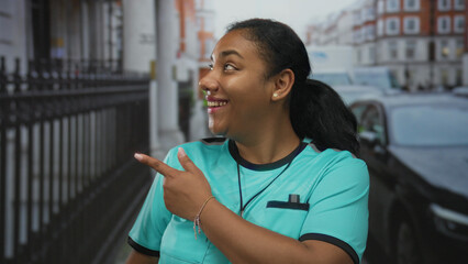 African american woman referee in teal uniform holds whistle glancing sideways smiling on busy...