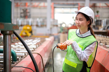 Engineer or worker operating remote switch to control machine in the factory