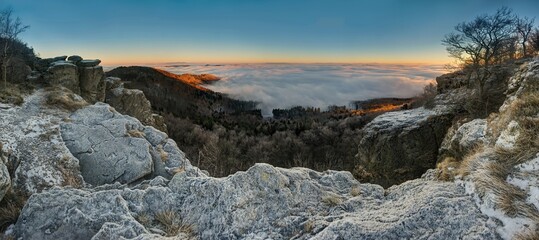 Beautiful foggy morning autumn atmosphere, stones covered with icing in the background of the hill...