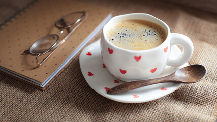 cup of coffee on a simple background, cozy home, notebook and coffee, coffee beans, flatlay,...