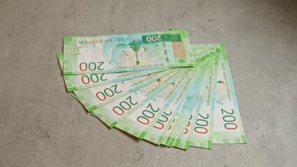 Russian rubles spread out on a concrete surface showcasing 200 denomination banknotes in a neat fan...