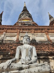 Thai Buddha Meditating against an Ancient Temple Ruins