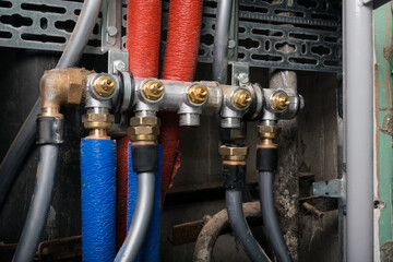 hot and cold water pipes are connected to the common comb, one connection is unscrewed, close-up