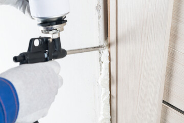 a gun for supplying mounting foam makes insulation of a doorway after installation by a master