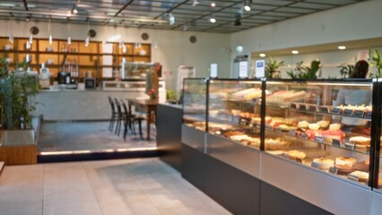 Interior of a restaurant with blurred man and woman browsing a variety of foods displayed in a...