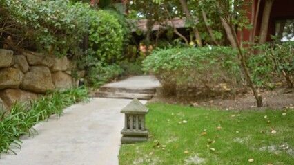 Blurry pathway in a luxury tropical resort garden with lush greenery and defocused background,...