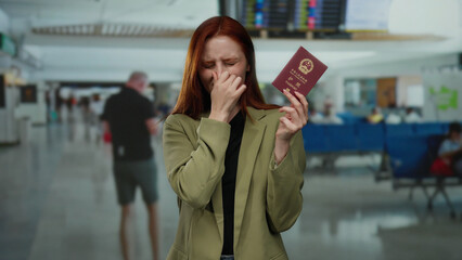 Woman holding chinese passport covers nose in busy airport terminal, indicating bad smell and...