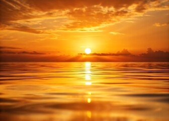 Naklejka premium Golden sunrise reflecting on peaceful ocean waves in a warm tropical glow.