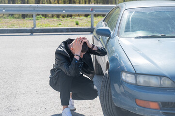 Caucasian man examines defects on his car body. 