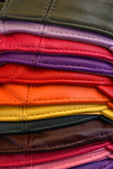 Colourful leather bags on a market stall for use as a background texture