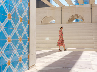 Young woman exploring Qasr Al Hosn Park in Abu Dhabi. Surrounded by lush greenery and historical...