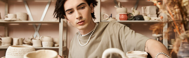 Handsome stylish man creating unique pottery in a bright and inspiring ceramics studio