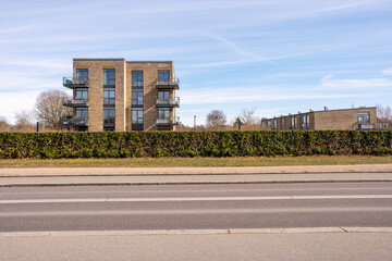 Modern low-rise building facing urban greenery with open sky, designed with symmetry and rhythm in mind, suitable as neutral background or for real estate and lifestyle themes